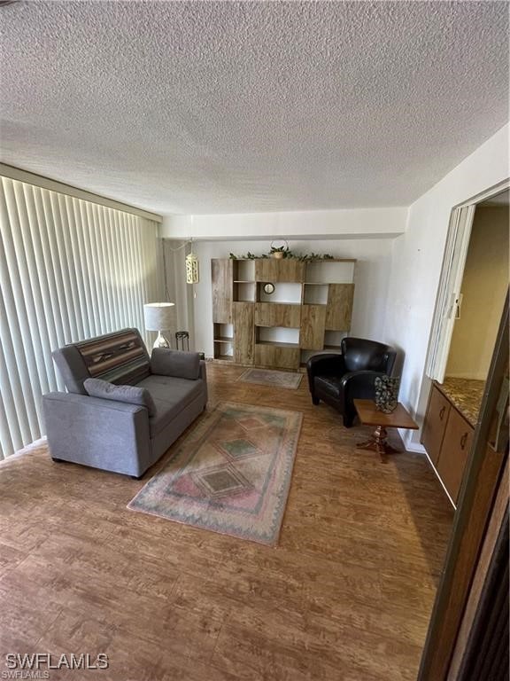 unfurnished living room with a textured ceiling and hardwood / wood-style floors