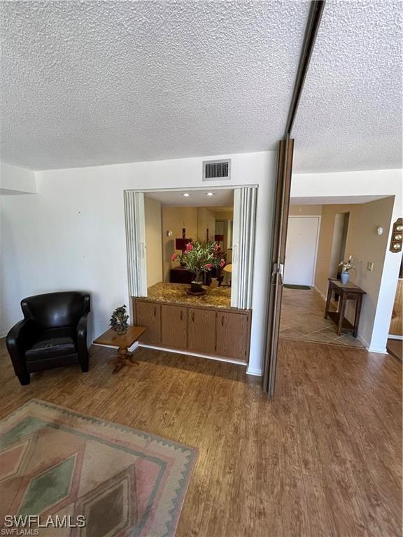 living room with a textured ceiling and hardwood / wood-style flooring