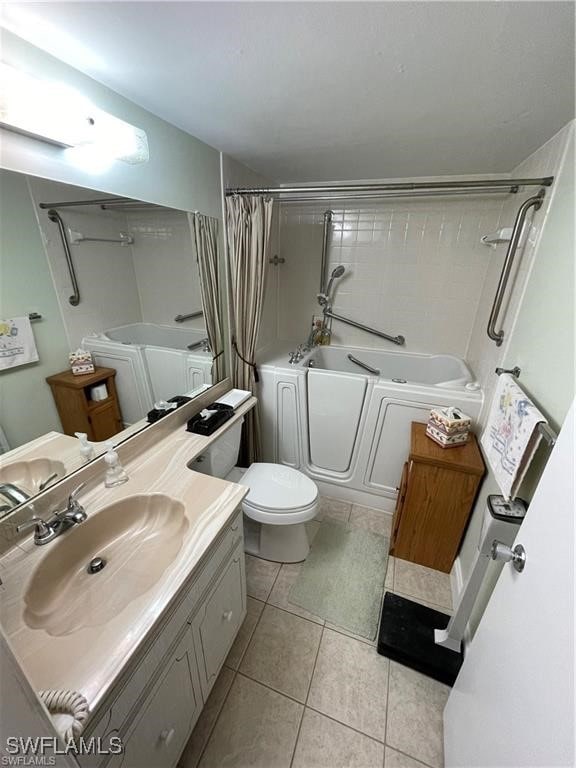 full bathroom featuring toilet, washing machine and clothes dryer, tile patterned flooring, shower / bath combo with shower curtain, and vanity