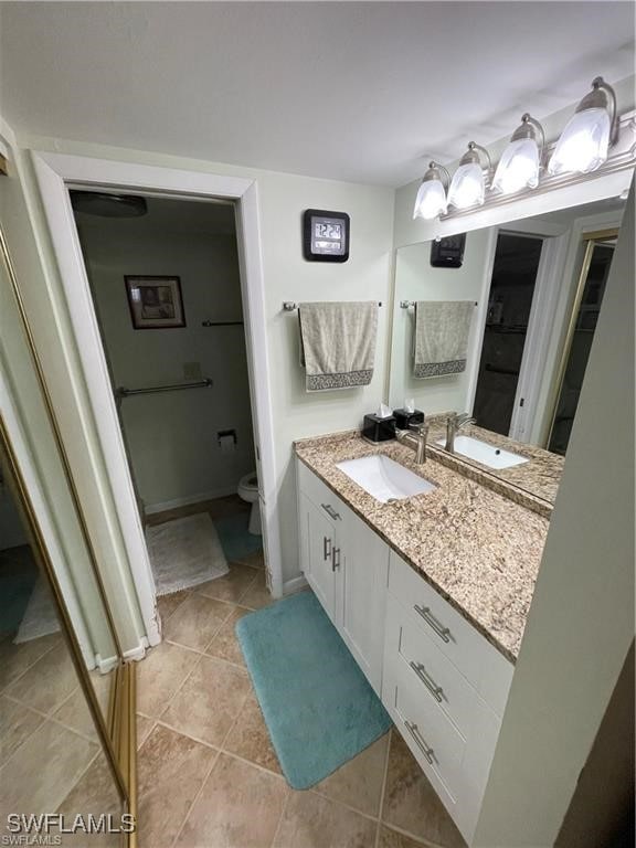 bathroom featuring toilet, vanity, and tile patterned flooring