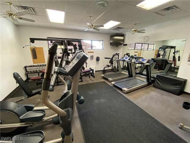 exercise room with a paneled ceiling and ceiling fan