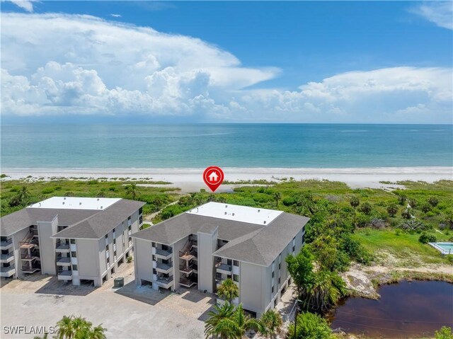 bird's eye view featuring a water view and a beach view