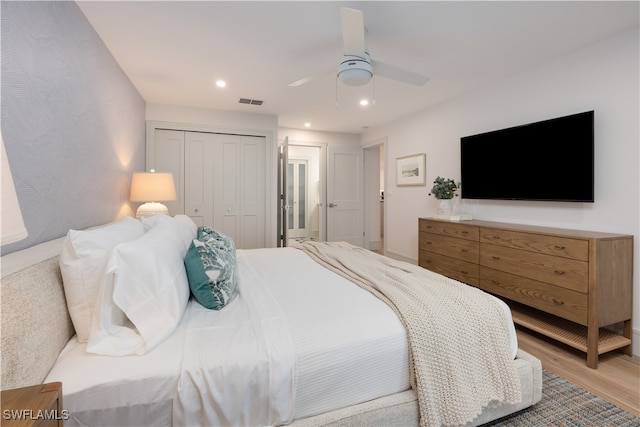 bedroom featuring light wood-type flooring, a closet, and ceiling fan