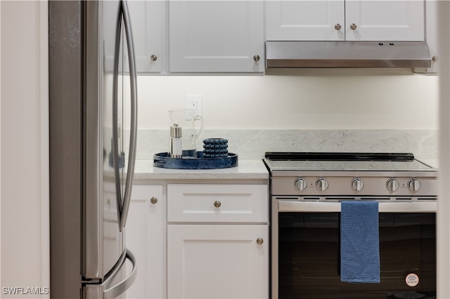 kitchen with stainless steel appliances, light stone countertops, and white cabinetry