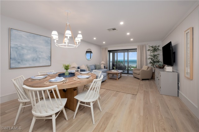 dining space featuring an inviting chandelier and light hardwood / wood-style floors