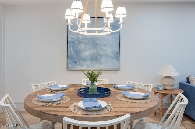 dining space with a notable chandelier and hardwood / wood-style flooring