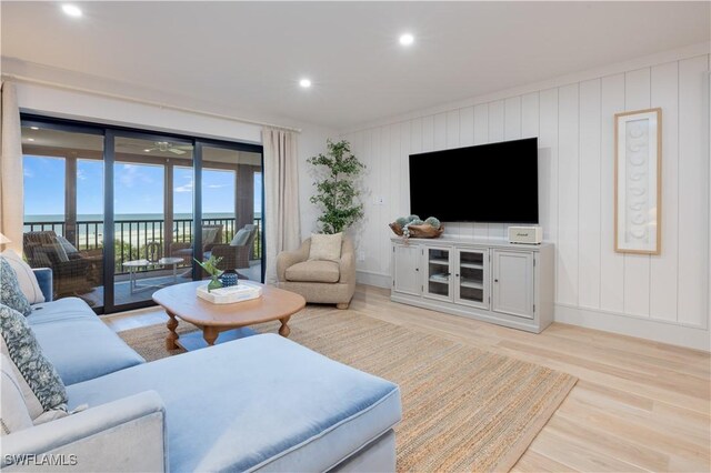 living room featuring light wood-type flooring and a water view