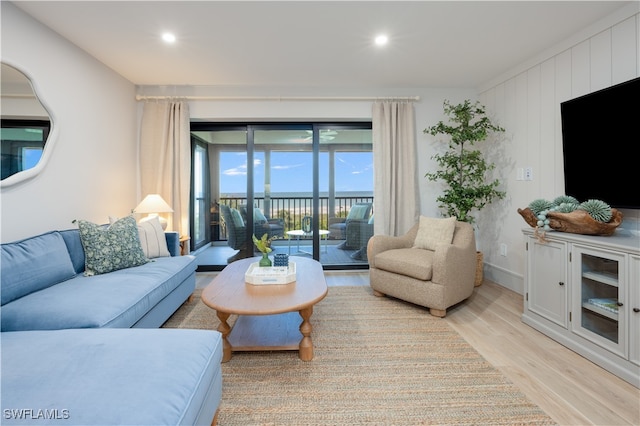 living room with light hardwood / wood-style flooring and wood walls