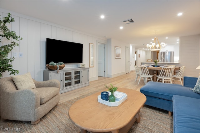 living room with a chandelier and light hardwood / wood-style floors