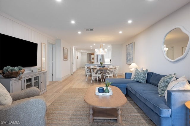 living room featuring light hardwood / wood-style flooring and a chandelier