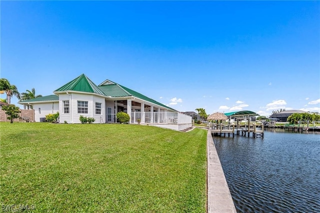 back of property featuring a water view and a lawn