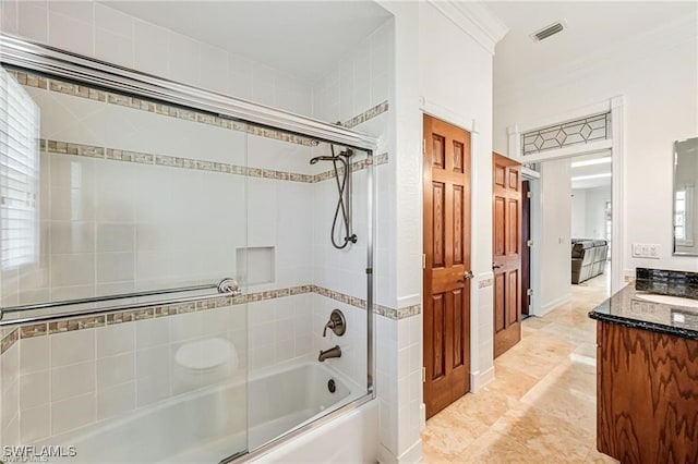 bathroom featuring enclosed tub / shower combo, vanity, and ornamental molding