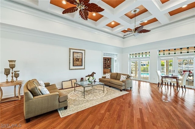 living room with beamed ceiling, coffered ceiling, french doors, ornamental molding, and ceiling fan