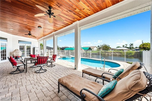 view of patio / terrace with ceiling fan, a fenced in pool, a water view, and french doors