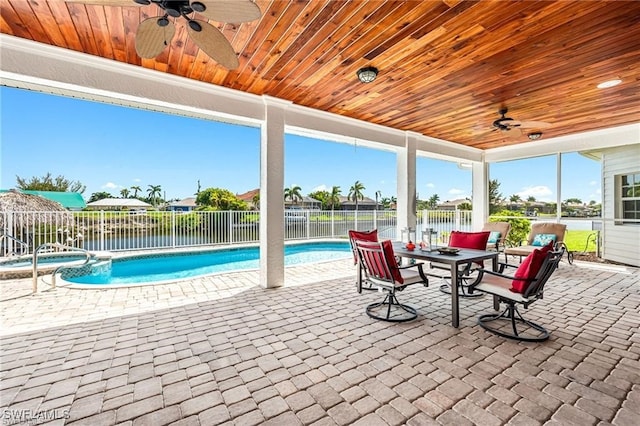 view of swimming pool featuring a patio, ceiling fan, and a water view