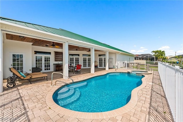 view of swimming pool featuring an in ground hot tub, ceiling fan, french doors, and a patio