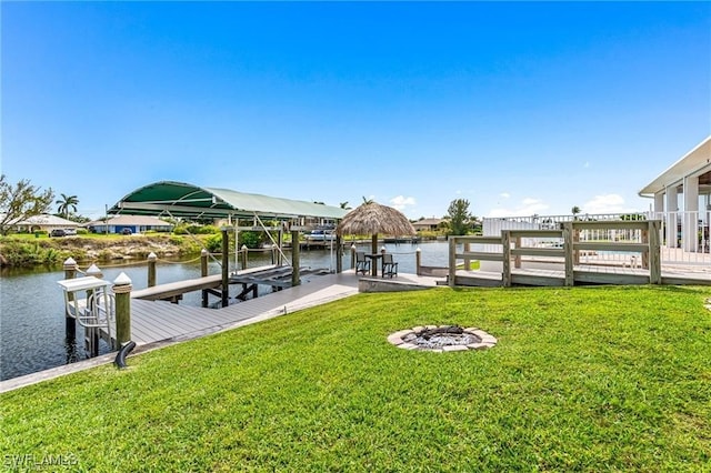 dock area with an outdoor fire pit, a water view, and a yard