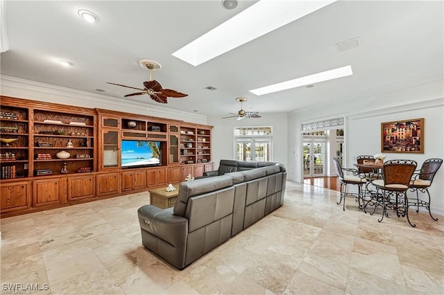 living room featuring crown molding, ceiling fan, and a skylight