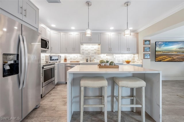 kitchen featuring pendant lighting, sink, a breakfast bar area, and stainless steel appliances