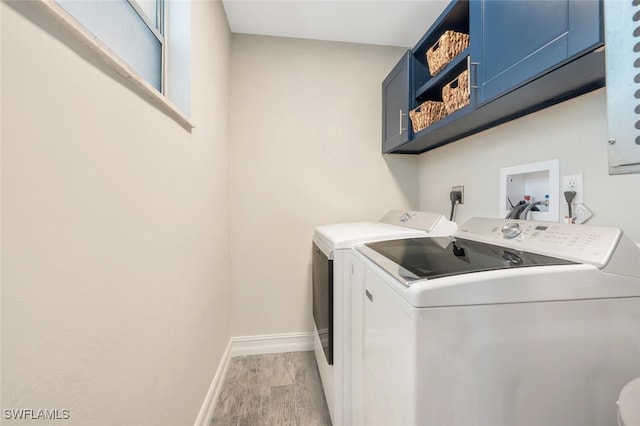 washroom featuring cabinets, light wood-type flooring, and independent washer and dryer