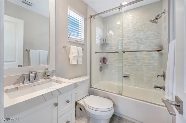 full bathroom with enclosed tub / shower combo, vanity, and toilet