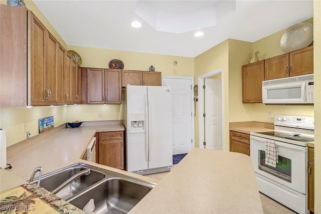 kitchen with light tile patterned flooring, white appliances, and sink