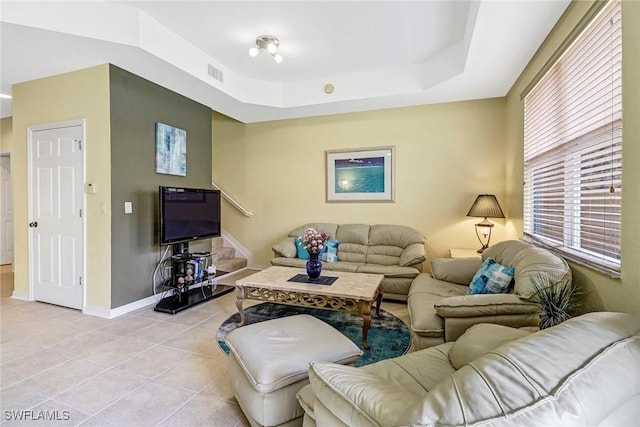 tiled living room featuring a tray ceiling