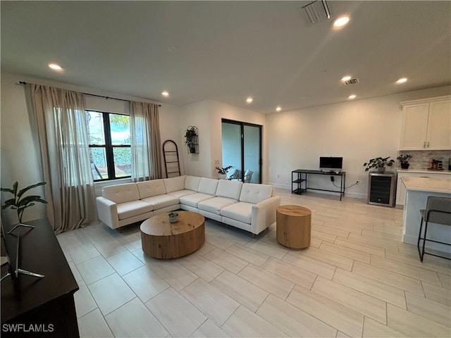 living room with beverage cooler, visible vents, and recessed lighting