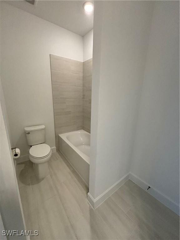 bathroom with wood finished floors, toilet, and baseboards