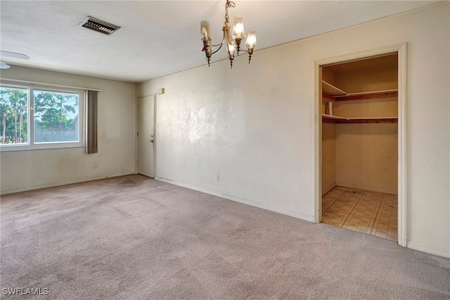 interior space with a spacious closet, carpet, a notable chandelier, and a closet