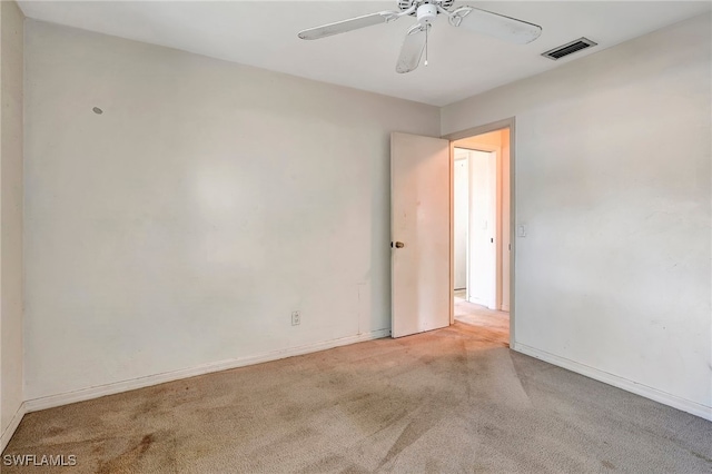 carpeted spare room with ceiling fan