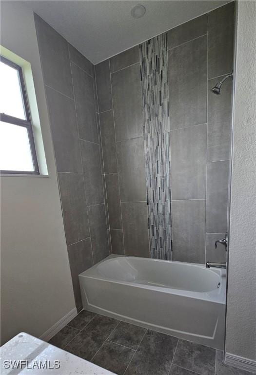 bathroom featuring tiled shower / bath combo and tile patterned floors