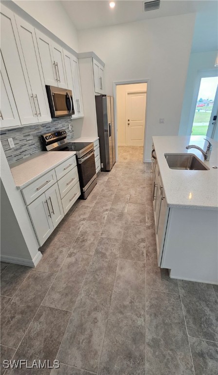 kitchen featuring sink, stainless steel appliances, tile patterned flooring, and tasteful backsplash