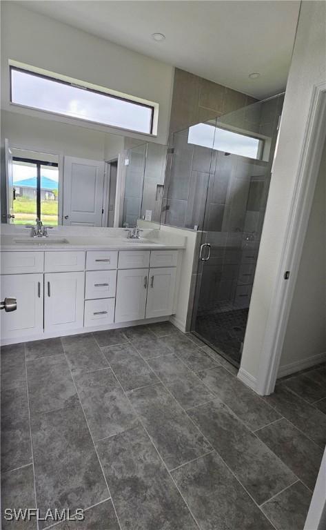 bathroom featuring tile patterned flooring, dual vanity, and walk in shower