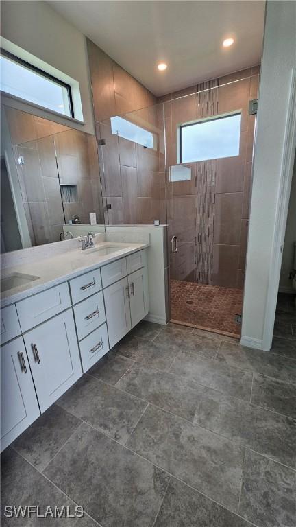 bathroom featuring dual bowl vanity, an enclosed shower, and tile patterned floors