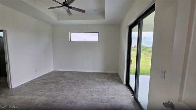 empty room with ceiling fan, tile patterned flooring, and a healthy amount of sunlight