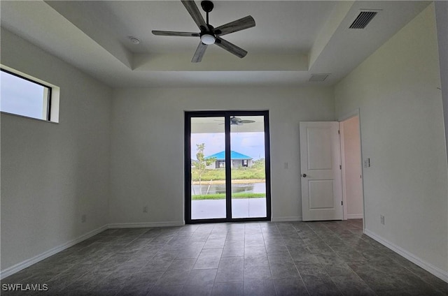 spare room featuring ceiling fan and a raised ceiling