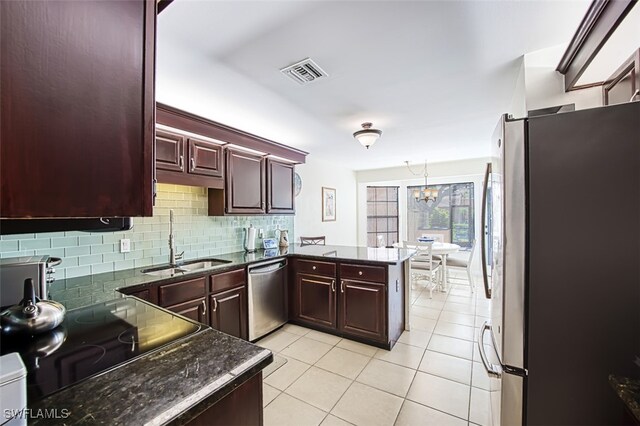 kitchen with sink, decorative light fixtures, light tile patterned floors, kitchen peninsula, and stainless steel appliances