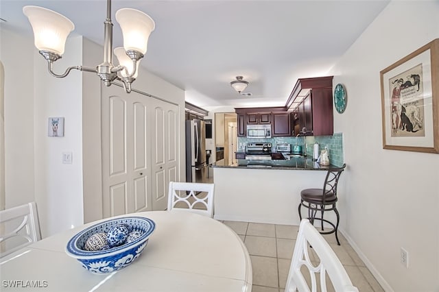 tiled dining room featuring a chandelier