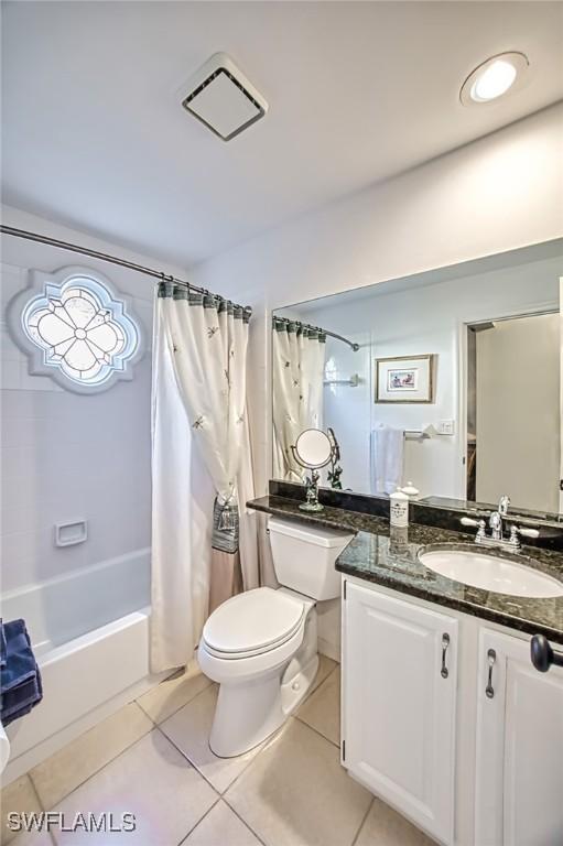 full bathroom with shower / tub combo, vanity, tile patterned floors, and toilet