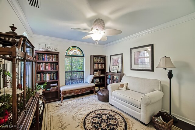 living area with ceiling fan and ornamental molding