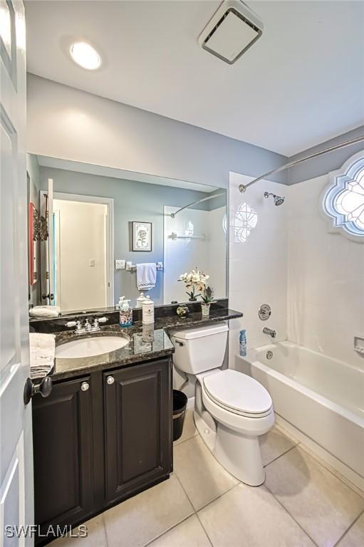 full bathroom featuring vanity, tiled shower / bath combo, tile patterned floors, and toilet