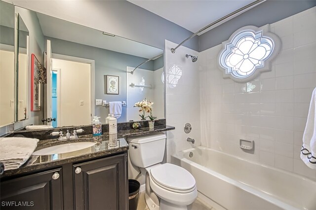 full bathroom with tiled shower / bath, vanity, and toilet