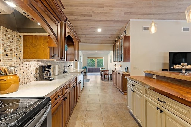 kitchen with butcher block countertops, wood ceiling, tasteful backsplash, cream cabinets, and light tile patterned flooring