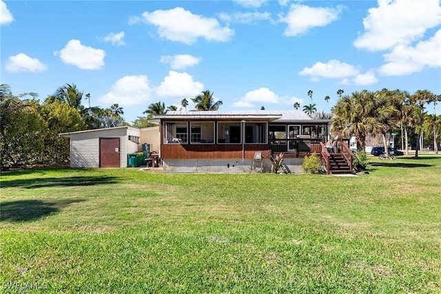 back of house with a storage unit, a yard, and a deck