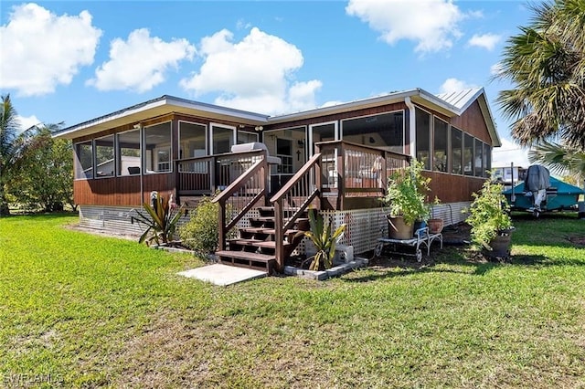 back of property with a sunroom and a yard