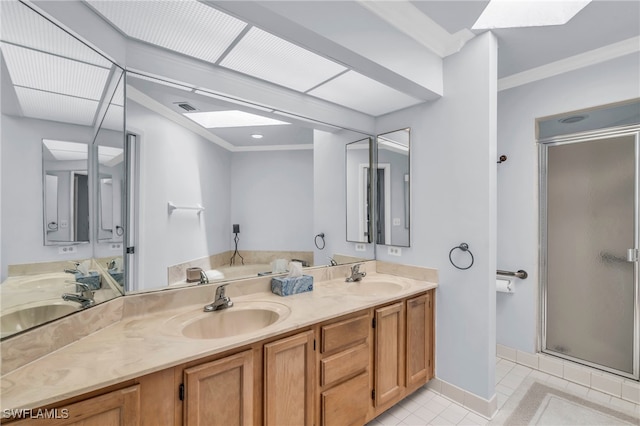 bathroom featuring a skylight, vanity, ornamental molding, tile patterned floors, and walk in shower