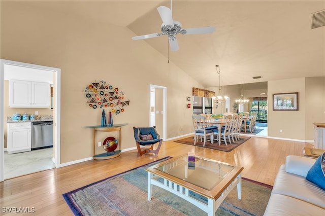 living room featuring light wood-type flooring, high vaulted ceiling, and ceiling fan with notable chandelier