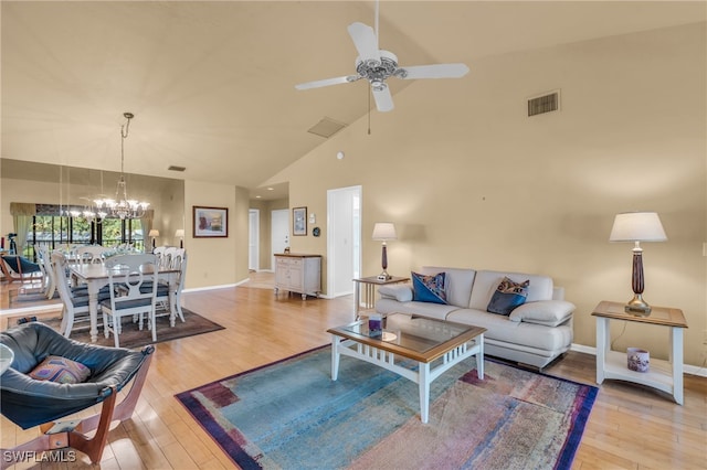 living room with high vaulted ceiling, light hardwood / wood-style flooring, and ceiling fan with notable chandelier