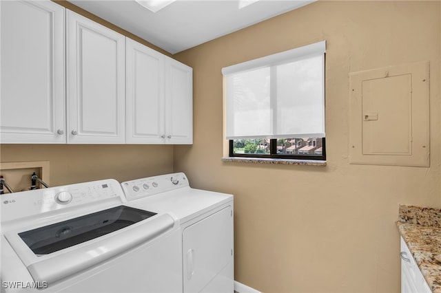 laundry area featuring washer and clothes dryer, cabinets, and electric panel